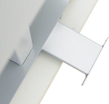 Nahaufnahme eines Metallbügels, der an einer ebenen Fläche befestigt ist, möglicherweise Teil eines Befestigungs- oder Trägersystems. Die Halterung ist rechteckig und aus Metall und ist an einer größeren Struktur befestigt.