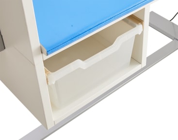 Nahaufnahme einer weißen Aufbewahrungseinheit mit einer blauen gepolsterten Oberfläche auf der Oberseite und einem durchsichtigen Kunststoffbehälter, der teilweise aus dem unteren Regal herausgezogen ist.