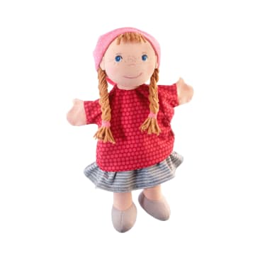Eine Stoffpuppe mit geflochtenem Garnhaar, die einen rosa Tupfenhut, ein rotes Kleid mit Tupfen, einen grau gestreiften Rock und graue Schuhe trägt, steht vor einem weißen Hintergrund.