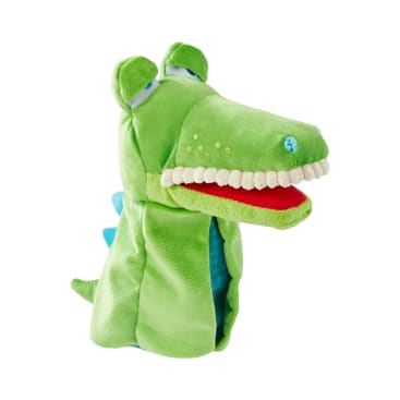 Eine grüne Plüschhandpuppe in Form eines Krokodils mit weißen Stoffzähnen, rotem Mund, blauen Rückenstacheln und gestickten Augen, dargestellt auf weißem Hintergrund.