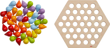 Auf der linken Seite ist ein Satz bunter, tropfenförmiger Spielsteine angeordnet, auf der rechten Seite ein sechseckiges Holzbrett mit kreisförmigen Löchern, die in einem Gitter angeordnet sind.