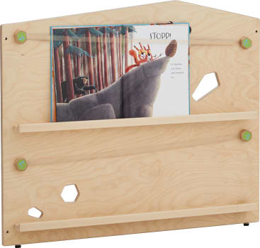 Ein Bücherregal aus hellem Holz mit einer schrägen Oberseite, grünen sechseckigen Schraubabdeckungen und zwei horizontalen Schienen, die ein aufgeschlagenes Kinderbuch mit einer Illustration von Tieren und Bäumen halten. Das Regal hat zwei sechseckige Ausschnitte.