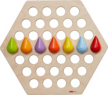 Ein sechseckiges Holzbrett mit sechs Reihen kreisförmiger Löcher, auf denen sieben bunte, tropfenförmige Holzteile in den Farben Grün, Gelb, Lila, Orange, Hellorange, Blau und Rot liegen.