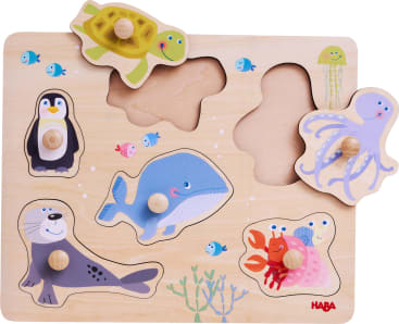 Ein hölzernes Puzzlebrett mit Abbildungen eines Pinguins, eines Wals, einer Robbe, einer Schildkröte und eines Oktopus. Die Teile der Schildkröte und des Oktopus werden angehoben und zeigen ihre leeren Steckplätze.