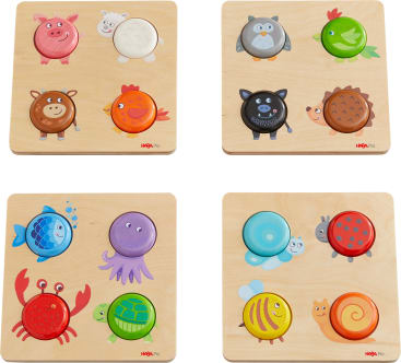 Vier hölzerne Tierpuzzles mit bunten, kreisförmigen Teilen; die Puzzles zeigen Cartoon-Bilder eines Schweins, eines Schafs, einer Eule, eines Vogels, eines Bären, eines Huhns, einer Krabbe, eines Fisches, einer Schildkröte, einer Schnecke und einer Biene auf einem hellen Holzhintergrund.