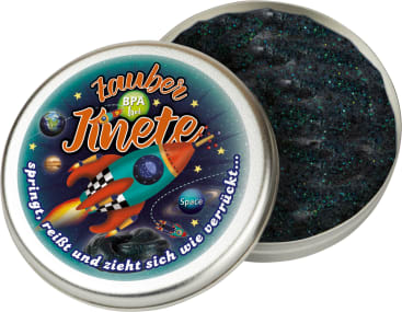 Eine runde Dose mit der Aufschrift "Zauber Knete" und einer bunten Rakete und Planeten auf dem Deckel ist geöffnet und gibt den Blick auf schwarze, glitzernde Knete frei. Das Etikett ist in deutscher Sprache und enthält Sätze über die Eigenschaften der Knete.