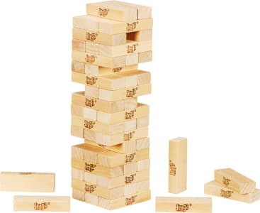 Ein teilweise gespielter Jenga-Turm aus hellen Holzklötzen steht auf einem weißen Hintergrund, wobei mehrere Klötze aus dem Turm entfernt und um seine Basis herum verstreut wurden.