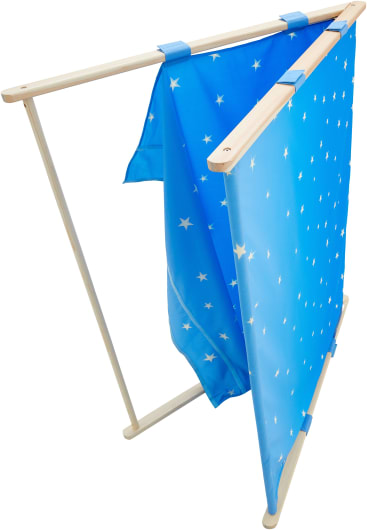 Ein Holzrahmen trägt zwei blaue Stoffbahnen mit weißen Sternmustern, die oben mit blauen Bändern befestigt sind. Das eine Paneel hängt ungleichmäßig, während das andere glatt herunterhängt. Der Hintergrund ist einfarbig weiß.