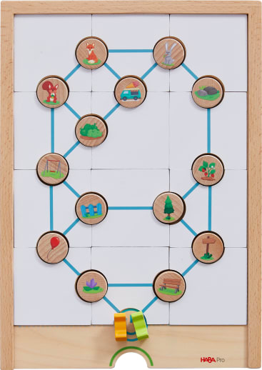 Auf dem hölzernen Spielbrett sind kreisförmige Spielsteine mit Motiven wie Fuchs, Auto, Kaninchen, Frosch, Luftballon und Baum abgebildet. Blaue Linien verbinden die Spielsteine, und ein gelber und grüner Marker befindet sich am unteren Rand des Brettes.