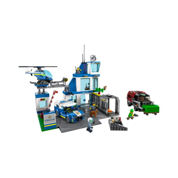 Ein LEGO Polizeirevier-Set mit einem blau-weißen Reviergebäude, einem Polizeiauto, einem Hubschrauber, einer Gefängniszelle, mehreren Minifiguren und einem roten und grünen Fluchtfahrzeug mit Zubehör und Requisiten.