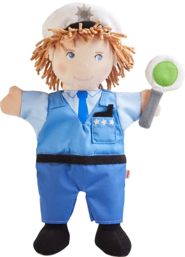 Eine Plüschhandpuppe in Form eines Polizisten mit hellbraunem Garnhaar, weißem Hut, blauer Uniform und einem Spielzeugabzeichen. Die Handpuppe hält in einer Hand ein rundes Schild mit einem grünen Kreis.
