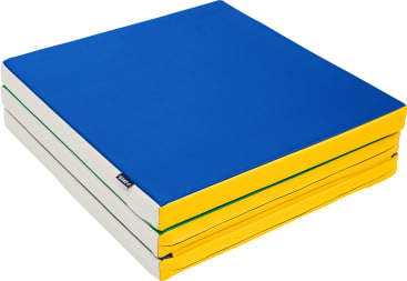Eine quadratische Schaumstoffmatte mit einer blauen Oberseite, gelben Seiten und weißen Lagen, ordentlich gestapelt. Die Matte hat auf einer Seite ein kleines schwarzes Etikett.