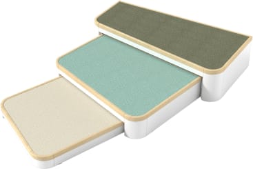 Drei mit Teppich ausgelegte rechteckige Stufen mit abgerundeten Kanten und weißen Seiten, die von links nach rechts aufsteigend angeordnet sind. Die Stufen haben unterschiedliche Farben: beige, helles aquamarin und olivgrün von unten nach oben.