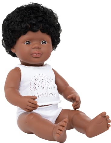 Eine dunkelhäutige Babypuppe mit lockigem schwarzem Haar, bekleidet mit einem weißen ärmellosen Oberteil und weißer Unterwäsche, sitzt aufrecht mit ausgestreckten Beinen und leicht angewinkelten Armen.