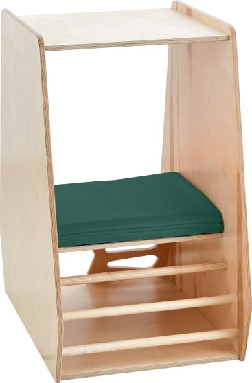 Ein Kinderstuhl aus Holz mit rechteckiger Form, grünem Kissen auf der Sitzfläche und drei horizontalen Holzstäben an der Basis, auf einer Seite offen, mit glatter, heller Holzoberfläche.