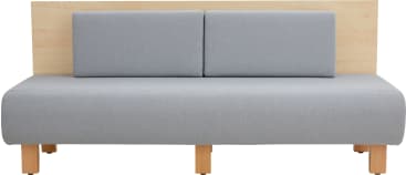 Ein modernes Sofa mit einer hellen Holzrückenlehne, zwei rechteckigen grauen gepolsterten Rückenkissen und einem passenden grauen Sitz. Das Sofa hat sechs Holzbeine und ein minimalistisches Design.